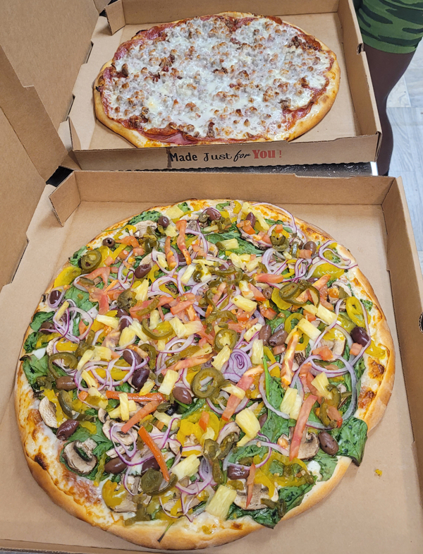 This is a picture of the pizza we sell. This is a from scratch mild Italian sausage, kalamata olives, and banana pepper topped pizza.
